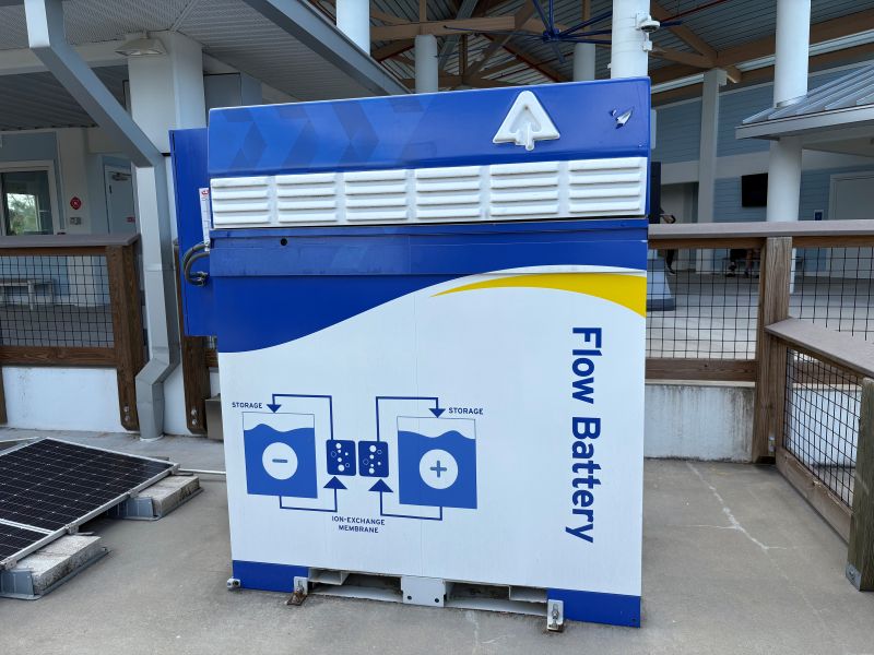 A Flow Battery is on display, used during a utility pilot program. The battery has a diagram on the side of it showing how it works.